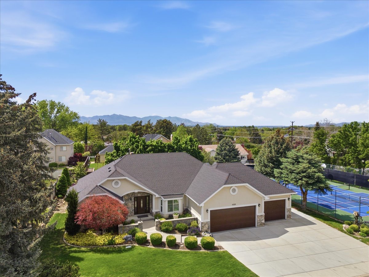 Exterior architecture featuring stone accents, a multi-car garage, and a concrete driveway