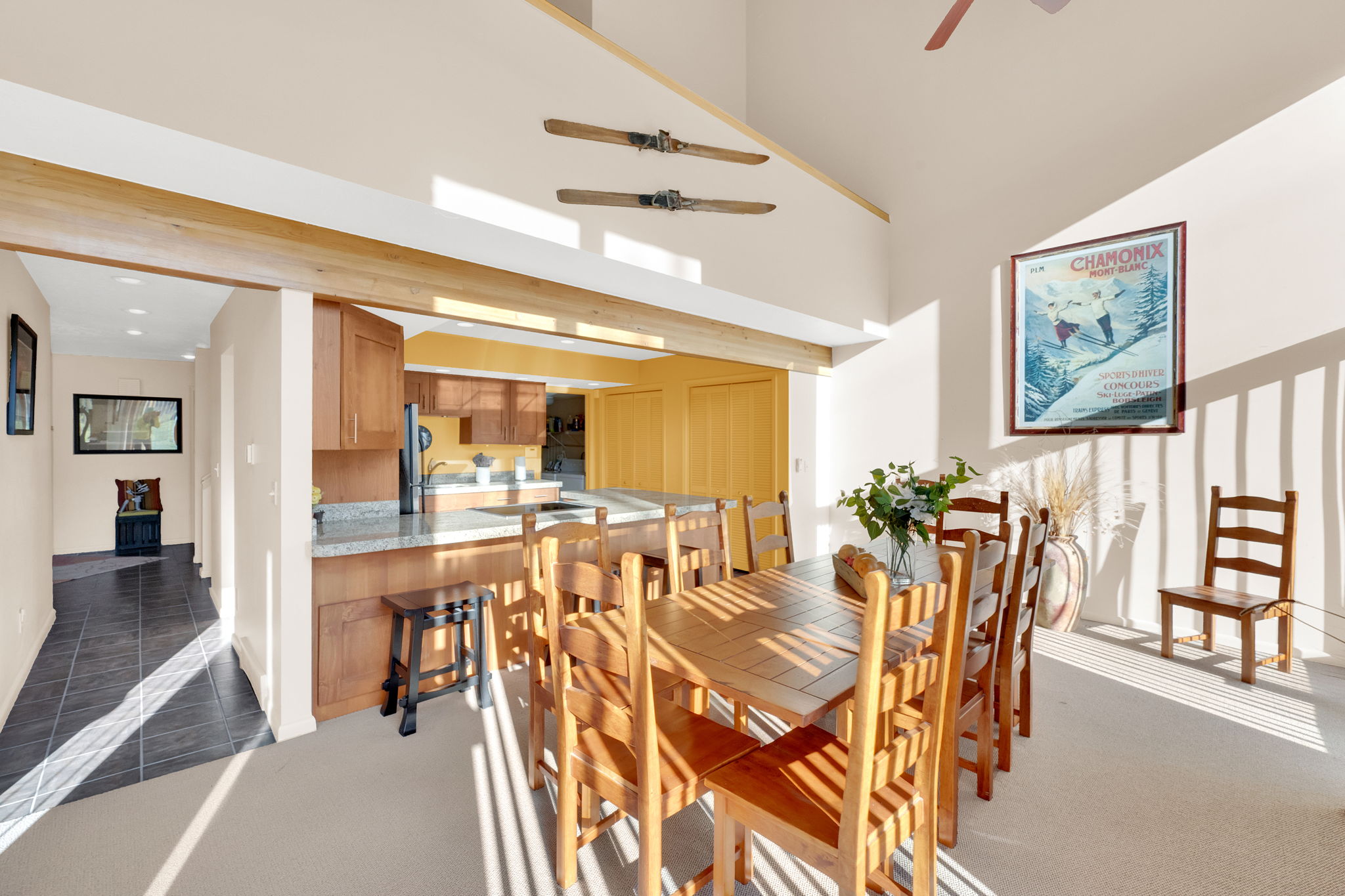 Open-concept dining area with vaulted ceilings and exposed wood beams