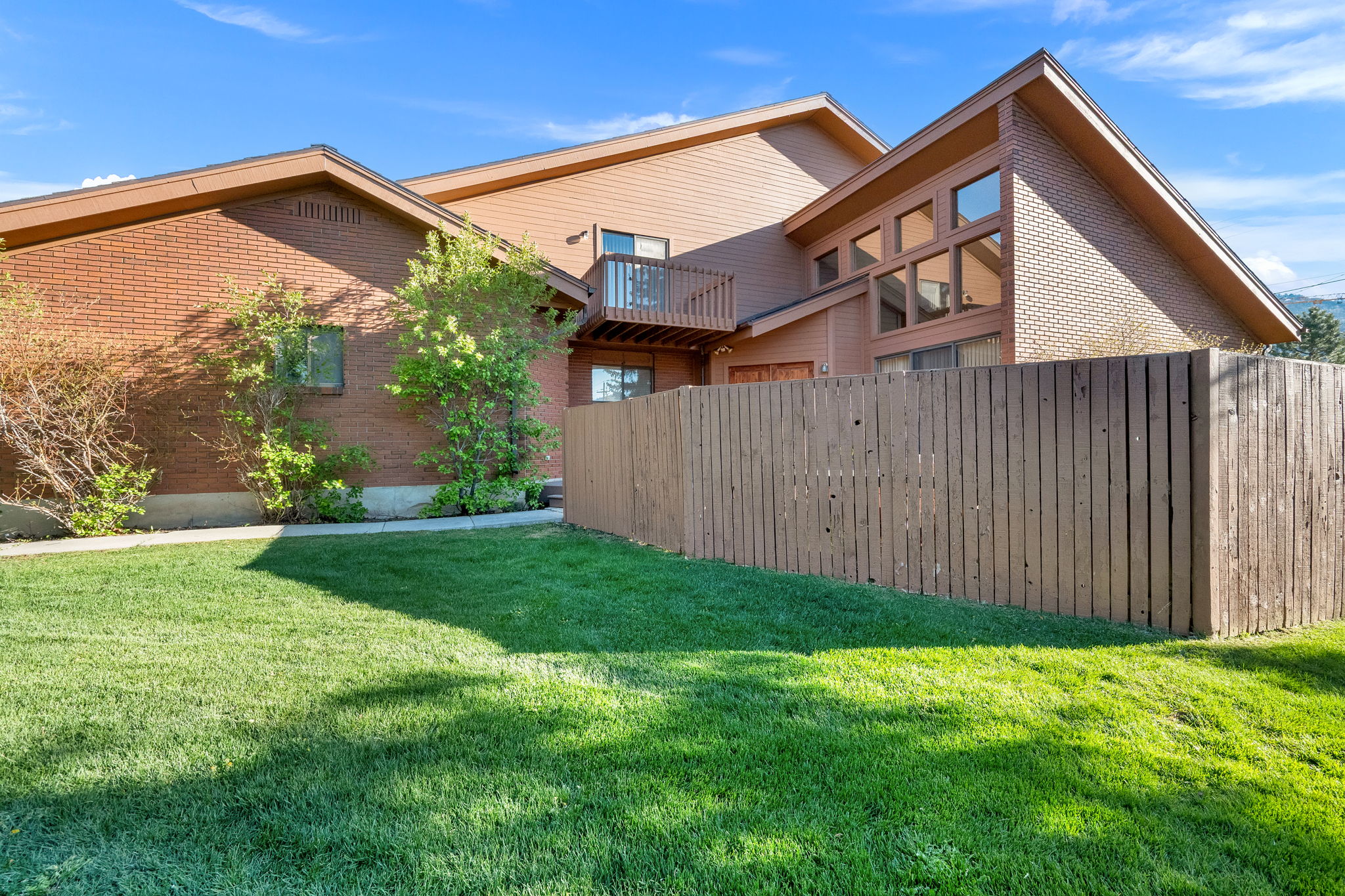 Expansive green lawn with a privacy fence