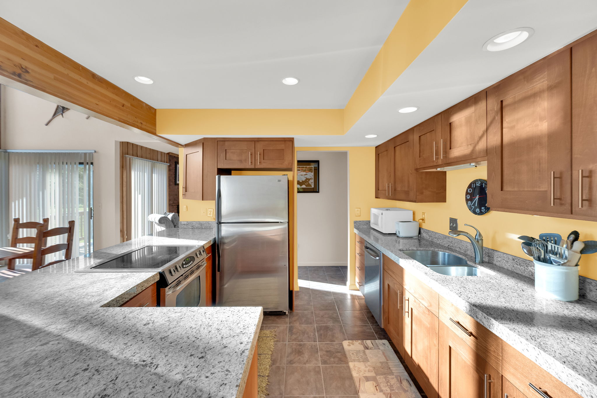 Kitchen featuring light wood-finish cabinetry, speckled countertops, stainless steel appliances, and recessed lighting