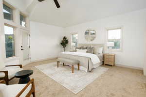 Carpeted bedroom with a vaulted ceiling and a ceiling fan