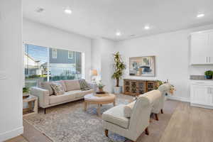Spacious living area featuring a large windows, natural light and recessed lighting, and LVP  flooring