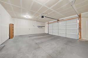 Spacious garage with a concrete floor, overhead lighting