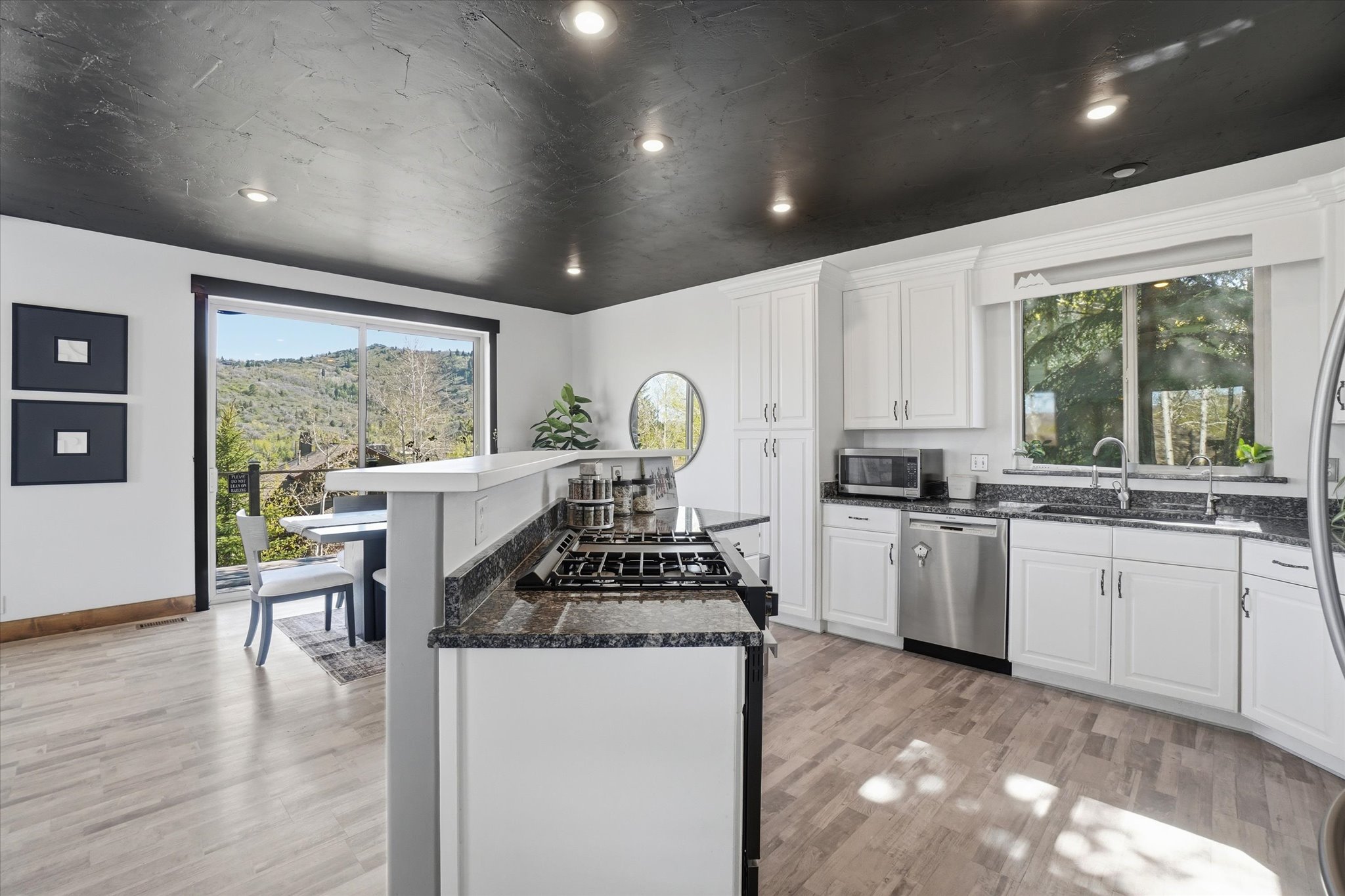Kitchen featuring white cabinetry, granite countertops, and stainless steel appliances