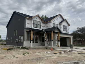 Newly constructed two-story residence featuring a dark gray facade and black-framed windows