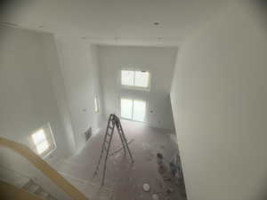 Two-story interior space featuring high ceilings, multiple windows, a built-in fireplace, and recessed lighting