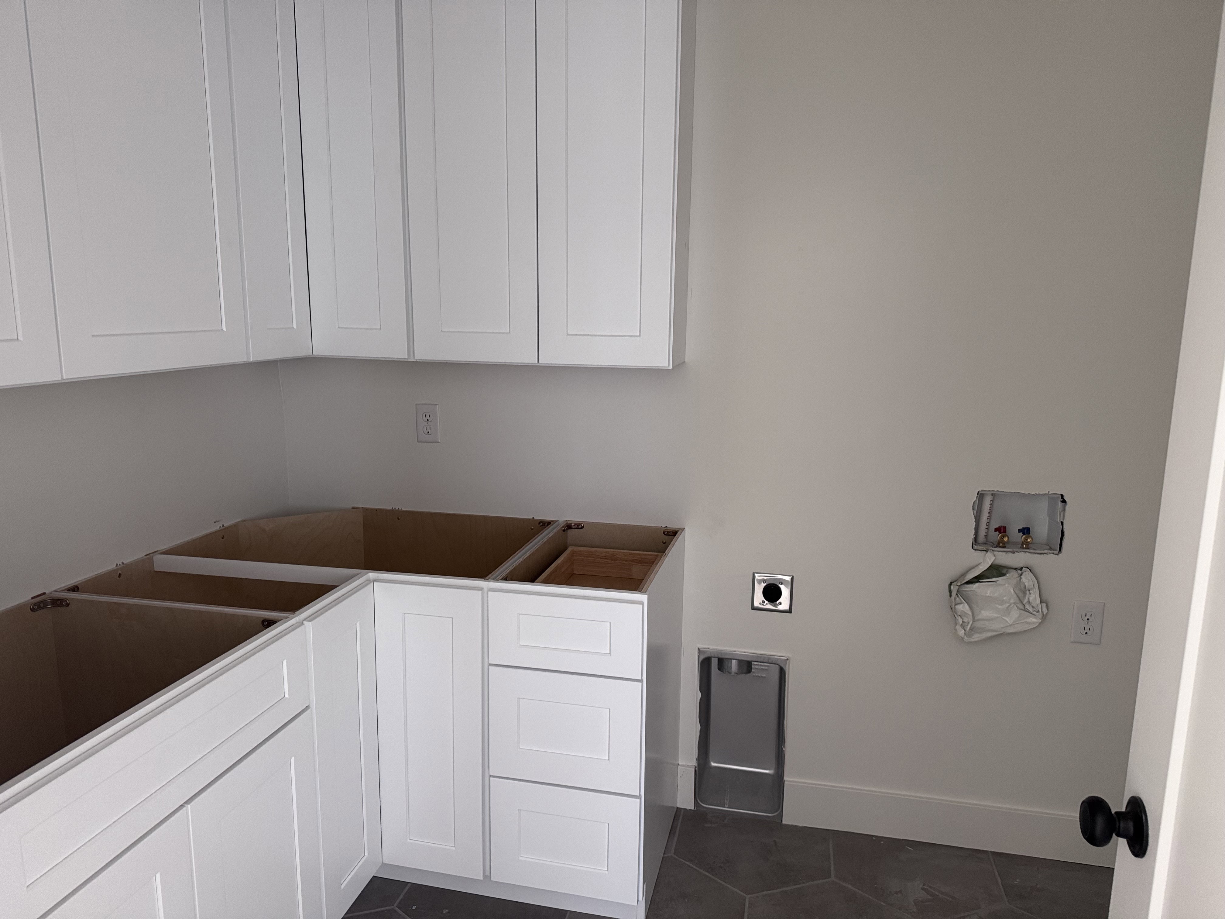 Room featuring white shaker-style cabinetry, hexagon tile flooring, and light-toned walls