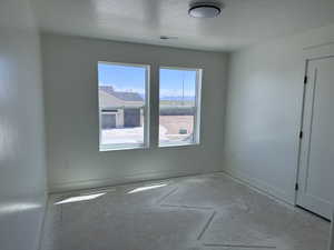 Bright interior space featuring two windows, a contemporary flush-mount ceiling light fixture, baseboard trim, and a paneled interior door