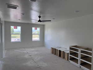 Spacious room with white walls, two large windows, a ceiling fan, and recessed lighting