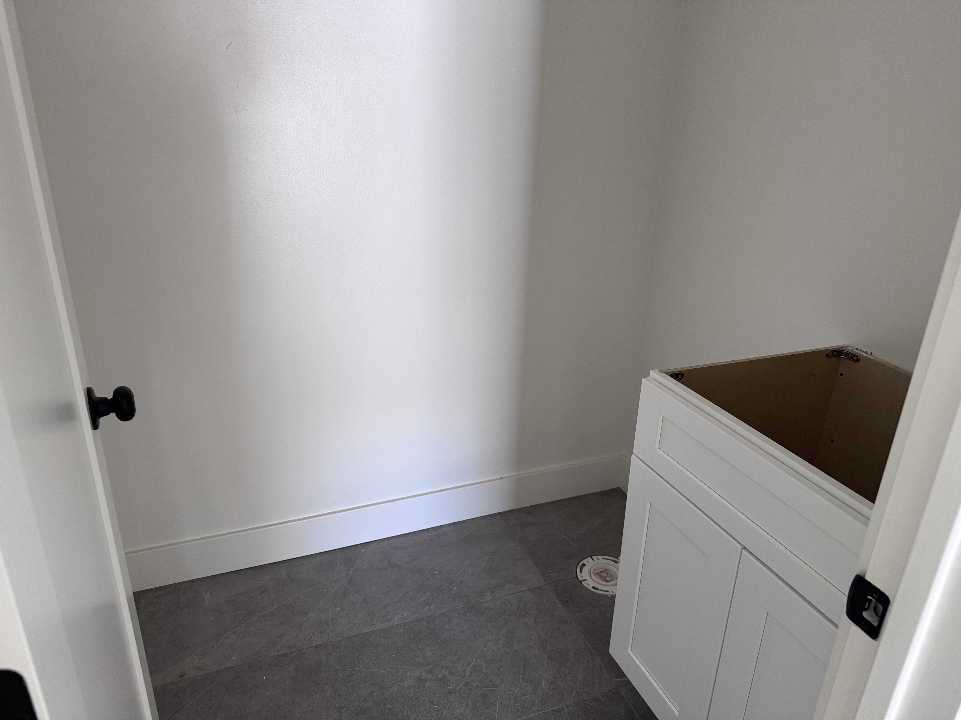 Room featuring dark grey floor tiles and white baseboards
