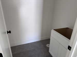Room featuring dark grey floor tiles and white baseboards
