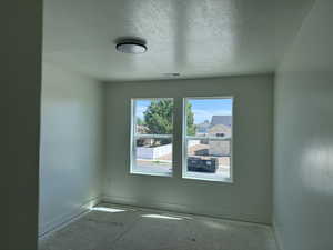 Bright room featuring two large windows, a flush-mount ceiling light fixture, and crisp white baseboards