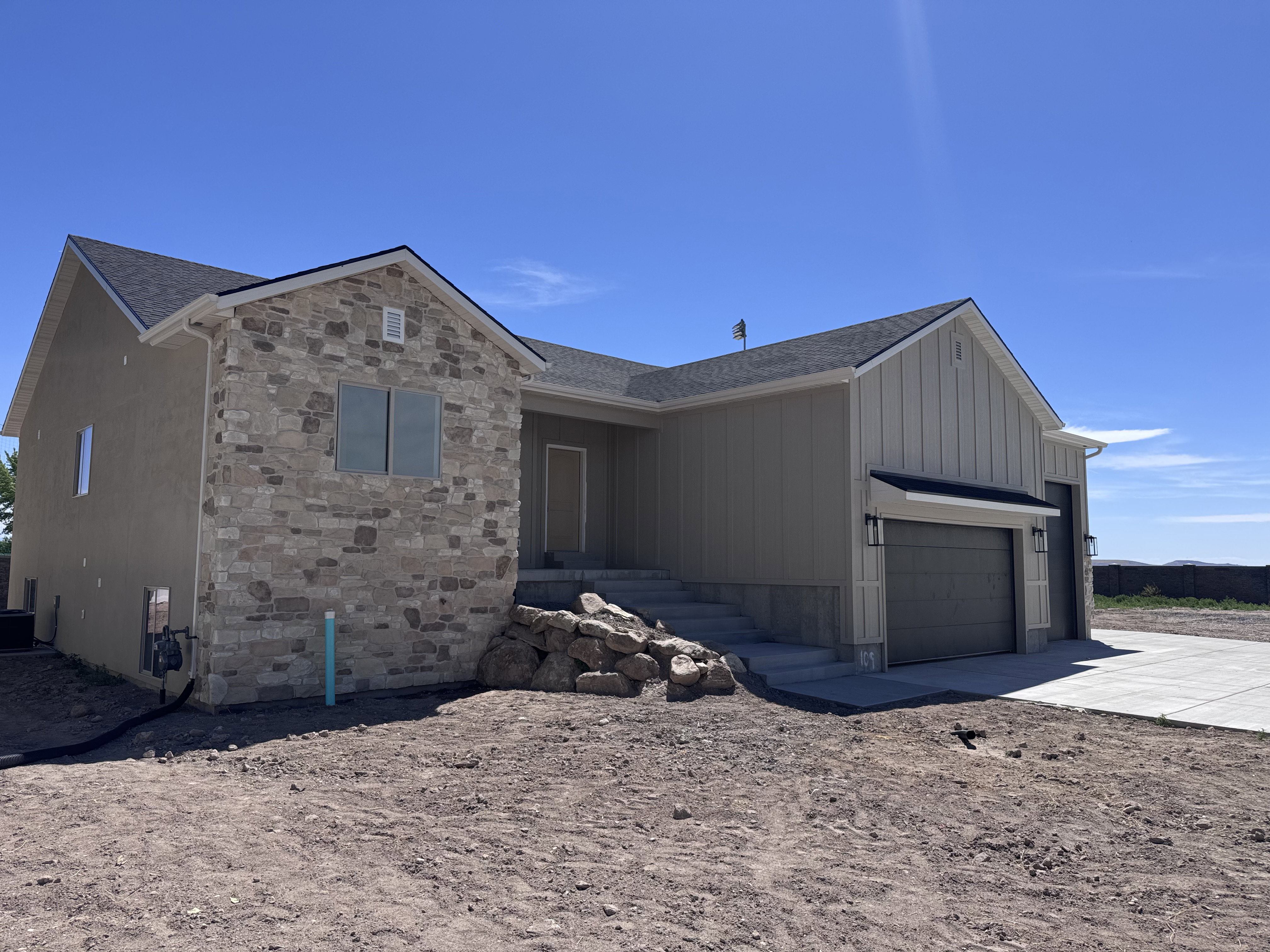 Contemporary exterior featuring a stone facade accent, board and batten siding, and an attached two-car garage