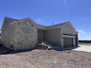 Contemporary exterior featuring a stone facade accent, board and batten siding, and an attached two-car garage