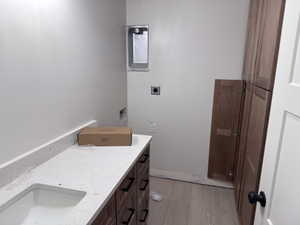 Utility space featuring a wood-finish flooring, built-in cabinetry, and a countertop with integrated sink