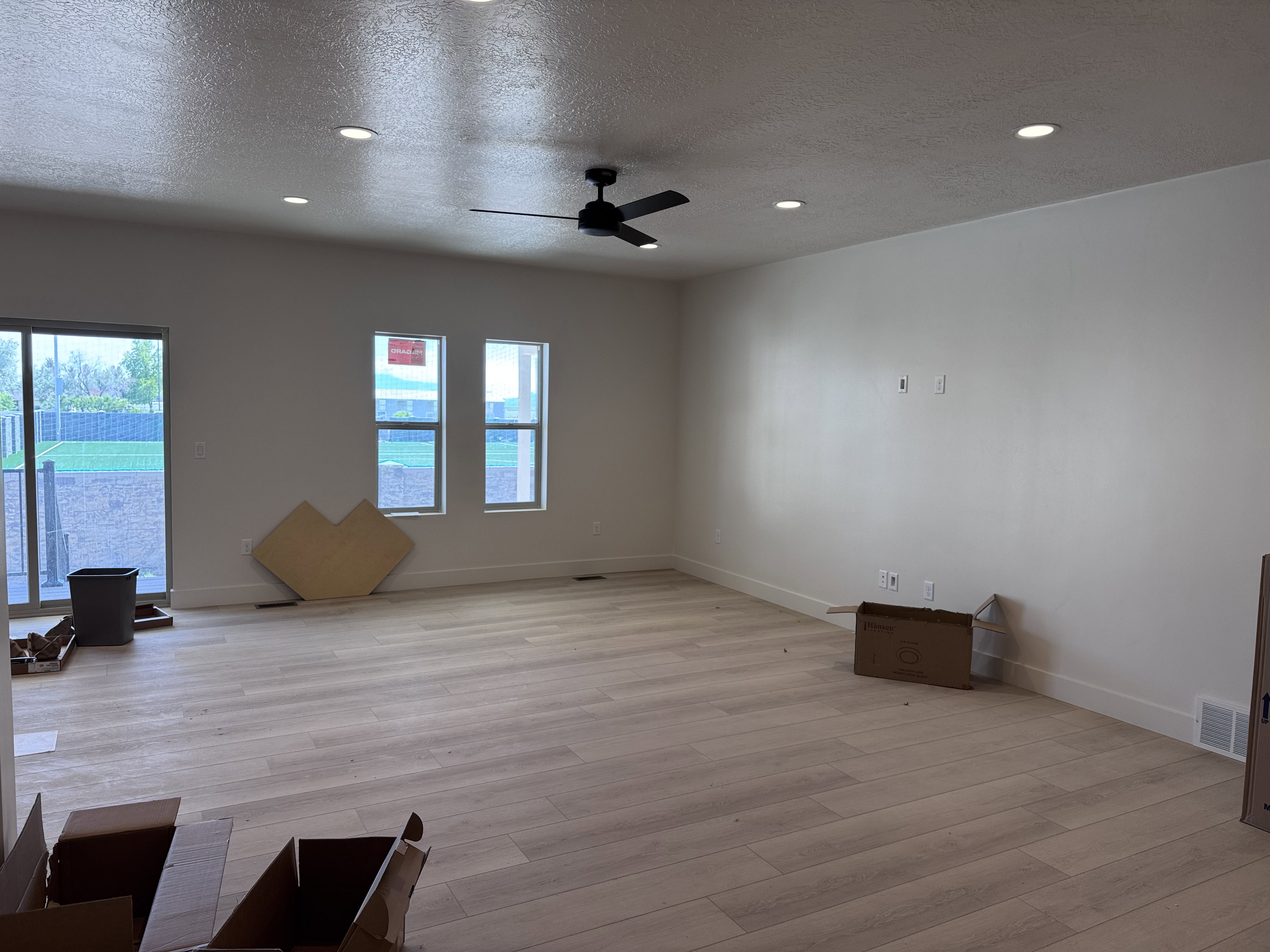 Expansive room featuring wood-finish flooring, recessed lighting, and a ceiling fan