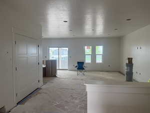 Spacious room with white walls, recessed lighting, and a sliding glass door