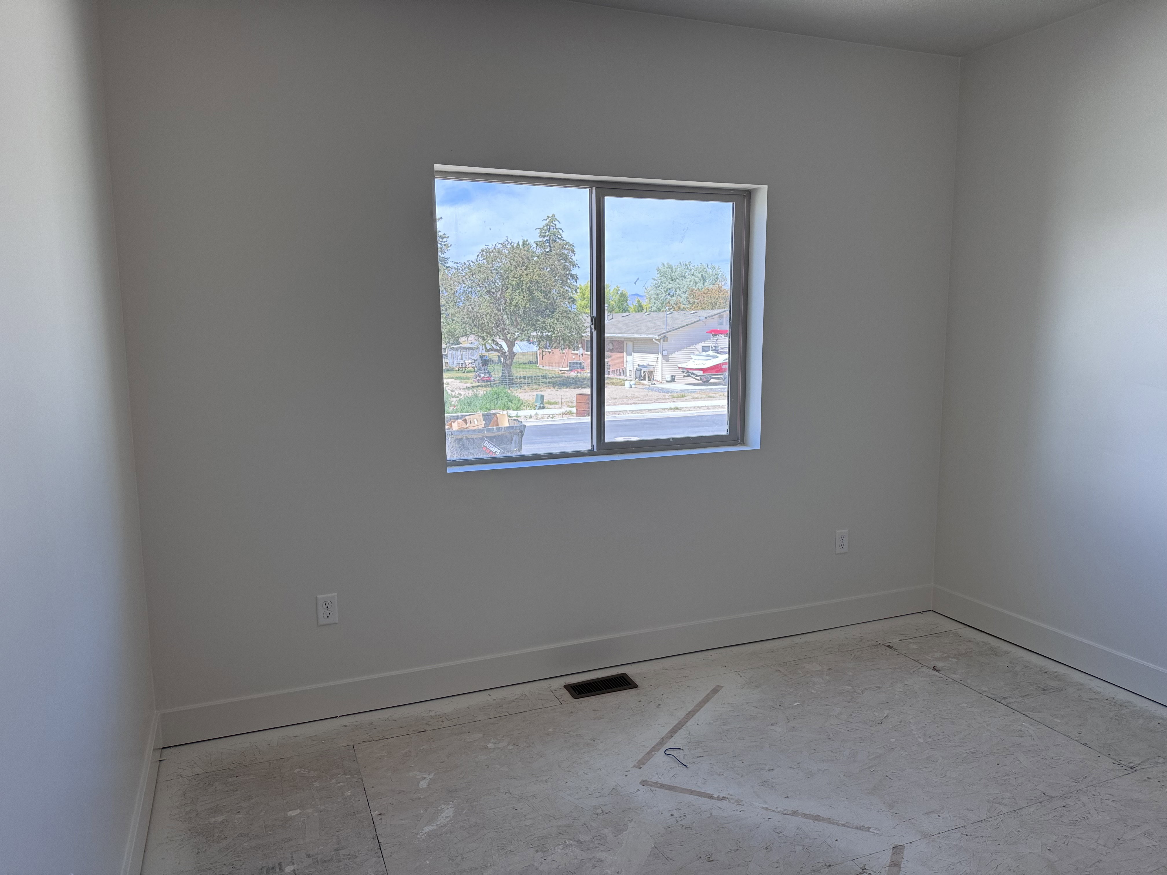 Unfinished room with neutral wall paint, a double-pane window, and white baseboards