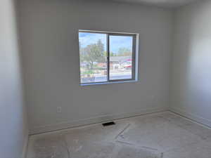 Unfinished room with neutral wall paint, a double-pane window, and white baseboards