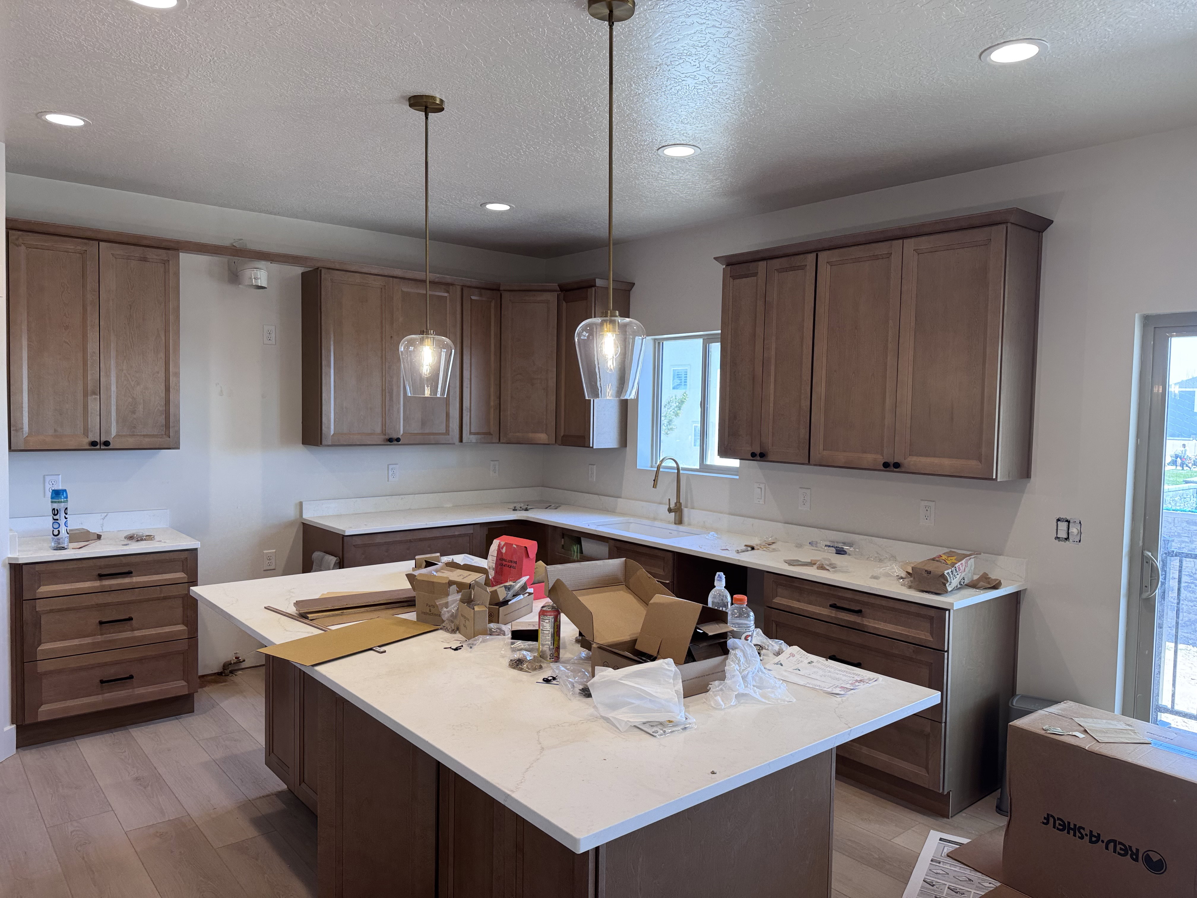 Kitchen featuring light wood-finish flooring, recessed ceiling lighting, and two glass pendant lights