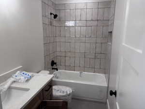 Bathroom featuring a tiled tub surround with a built-in niche, matte black fixtures, and a white bathtub