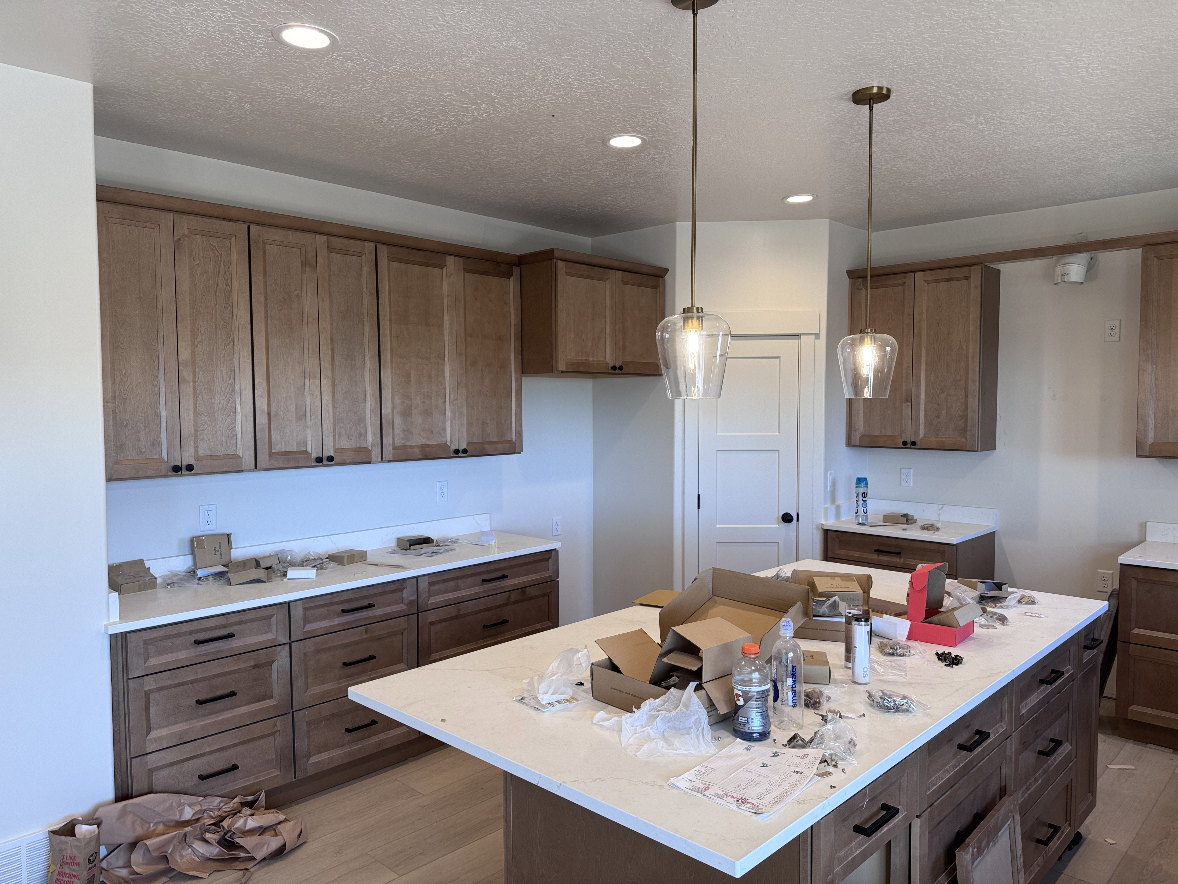 Kitchen featuring a large central island with light-toned countertops, warm wood-finish cabinetry, and recessed lighting