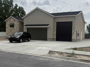 Modern exterior featuring board and batten siding, stone accents, and a dark asphalt shingle roof