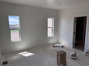 Bright interior room featuring a large doorway, two distinct windows, and recessed lighting
