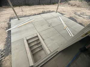 Concrete patio with a built-in stairwell leading below grade