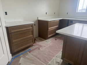 Custom cabinetry with a rich wood-tone finish, complemented by white countertops featuring subtle veining