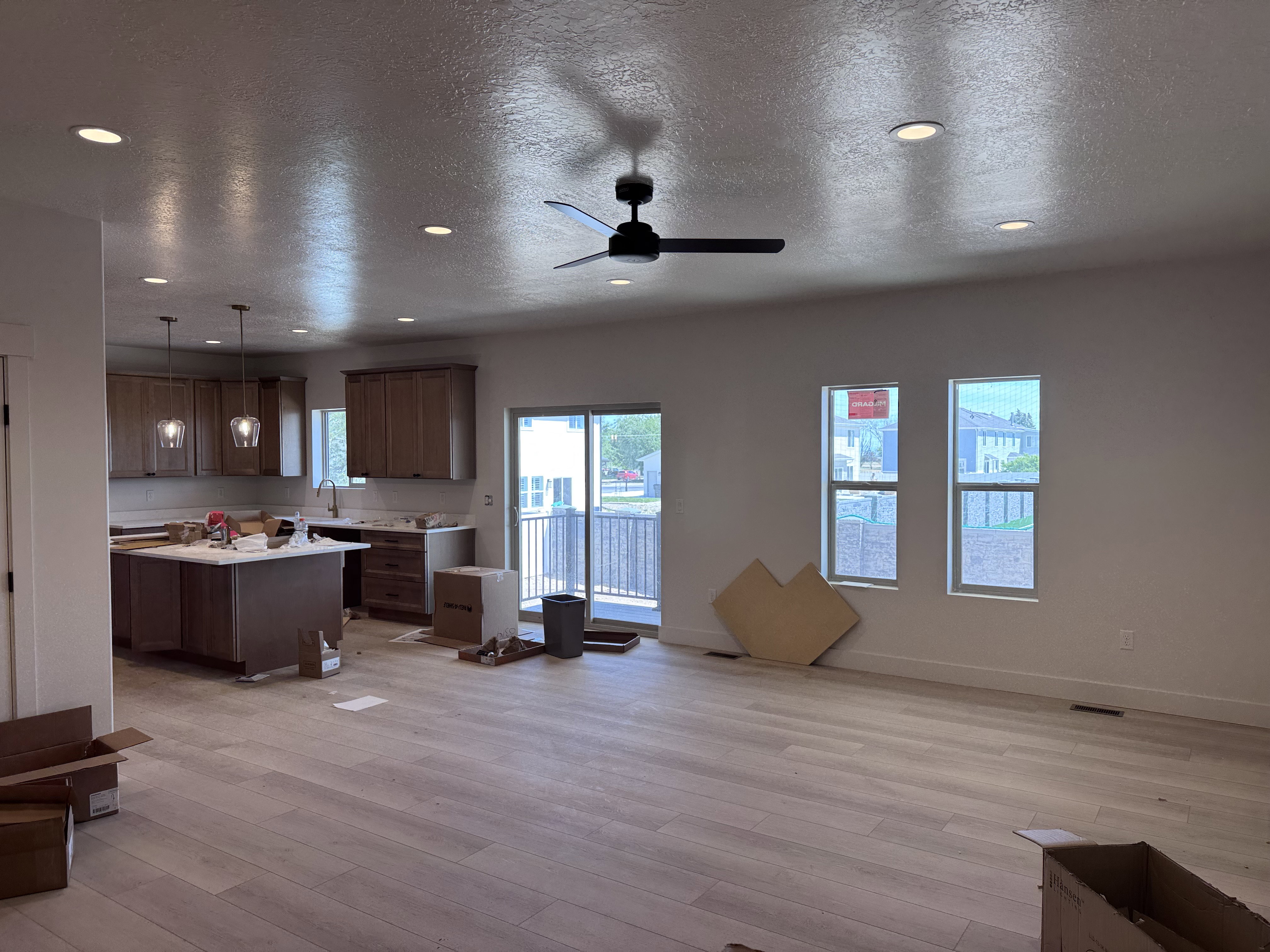 Open-concept living area featuring light wood-finish flooring, recessed lighting, and a contemporary ceiling fan