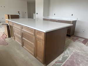 Kitchen island with light-toned wood cabinetry and a white countertop