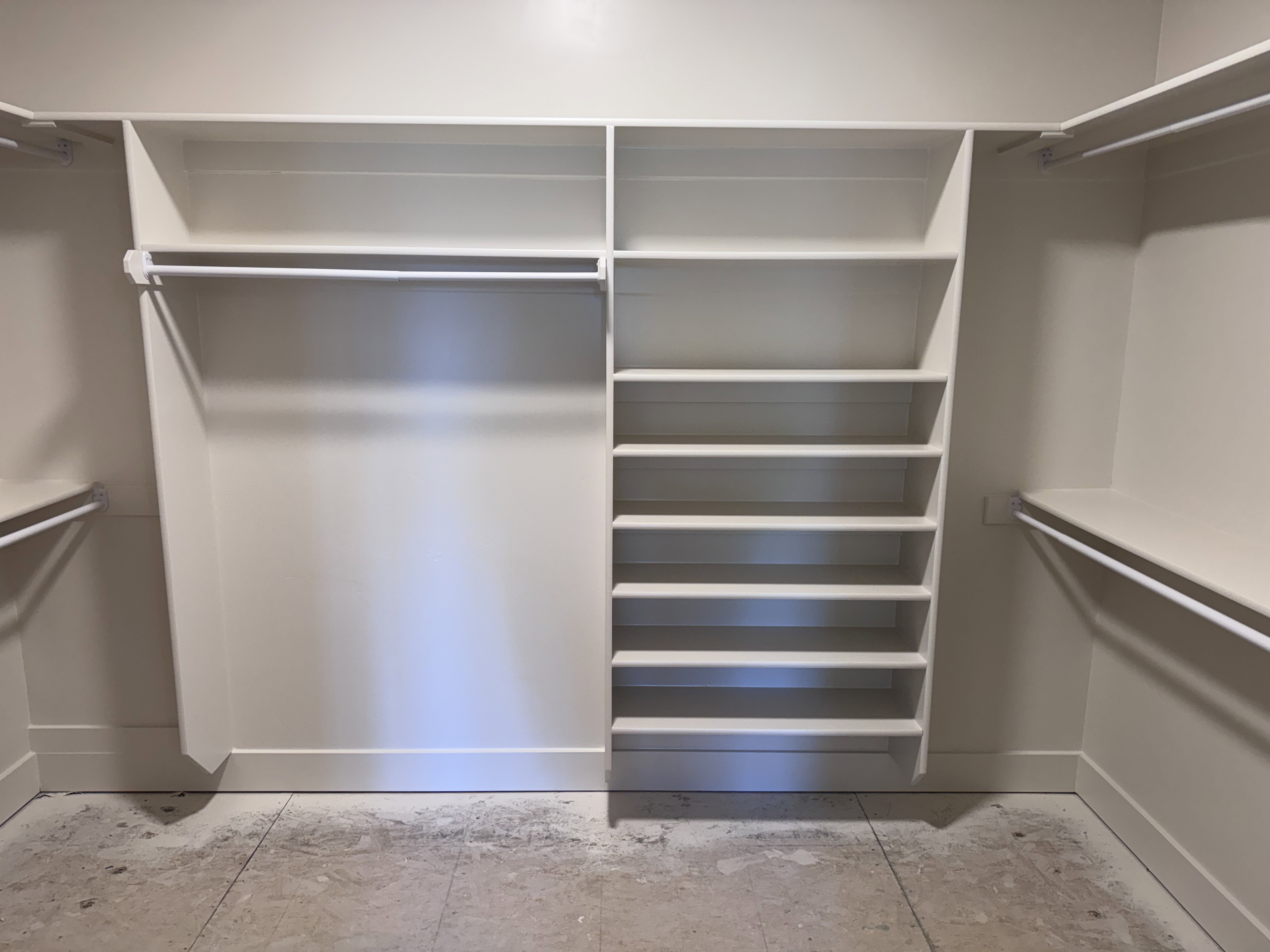Walk-in closet featuring built-in shelving, multiple hanging rods, and an integrated shoe rack