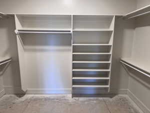 Walk-in closet featuring built-in shelving, multiple hanging rods, and an integrated shoe rack