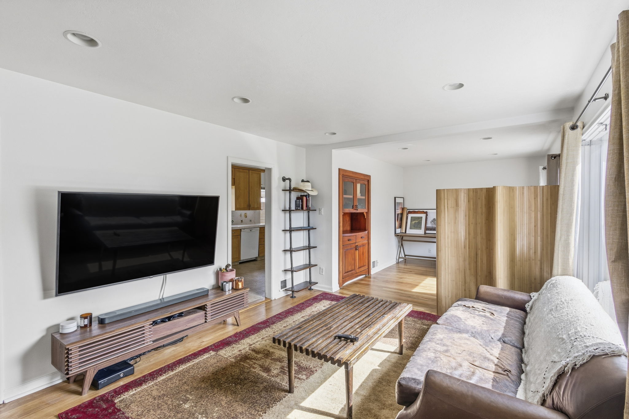 Open-concept living space with recessed lighting, wood-finish flooring, and crisp white walls
