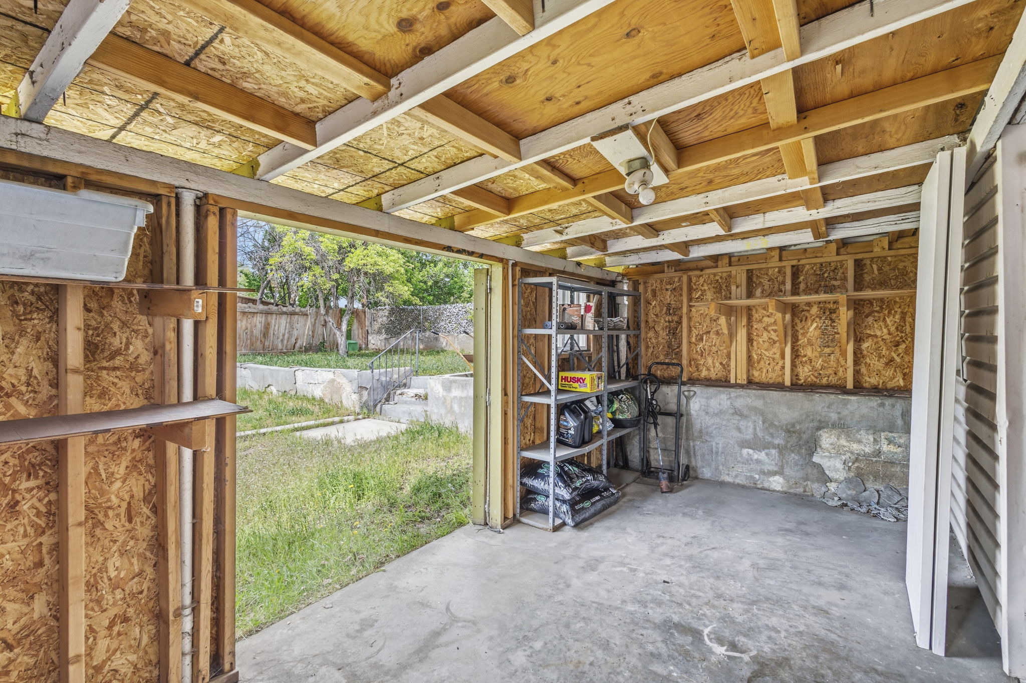Open-air structure with exposed wood framing and a concrete floor