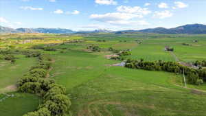 Expansive green landscape featuring distant mountain ranges with snow-capped peaks