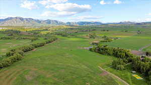 Expansive green fields with distant mountains under a blue sky