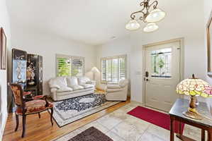 Entryway featuring a decorative frosted glass door, tile flooring, and a wrought iron chandelier