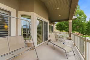 Covered outdoor patio featuring recessed lighting, a white railing, and multiple glass sliding doors
