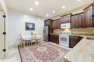Kitchen featuring wood cabinetry, granite-style countertops, and tile flooring