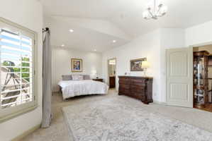 Spacious interior room featuring vaulted ceilings, recessed lighting, and a neutral carpeted floor