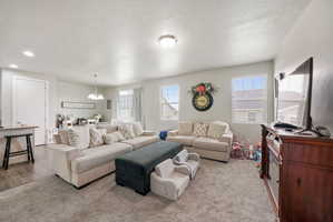 Expansive living area featuring light-toned walls, recessed lighting, and multiple windows