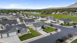 Residential neighborhood with paved streets and sidewalks, featuring single-story homes with dark roofs and light-colored siding