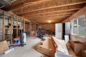 Unfinished basement featuring exposed wood joists and concrete flooring