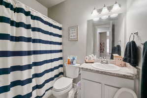 Bathroom vanity with a rectangular mirror, a three-light fixture, and a single-basin sink