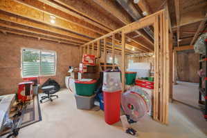 Unfinished basement with exposed wood framing, concrete floor, and visible insulation