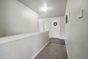 Entryway featuring a paneled door, wood-finish flooring, and soft gray wall tones