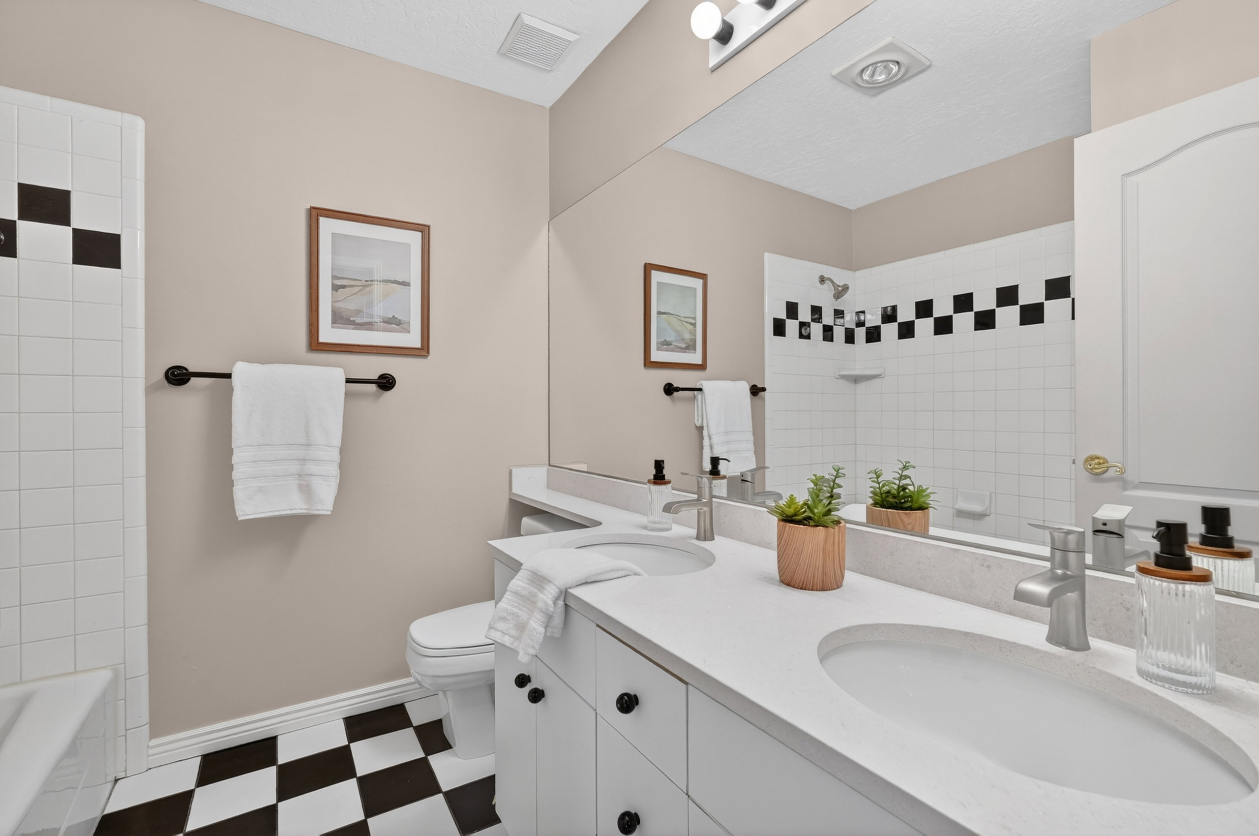 Bathroom featuring a dual vanity with integrated sinks and a large mirror