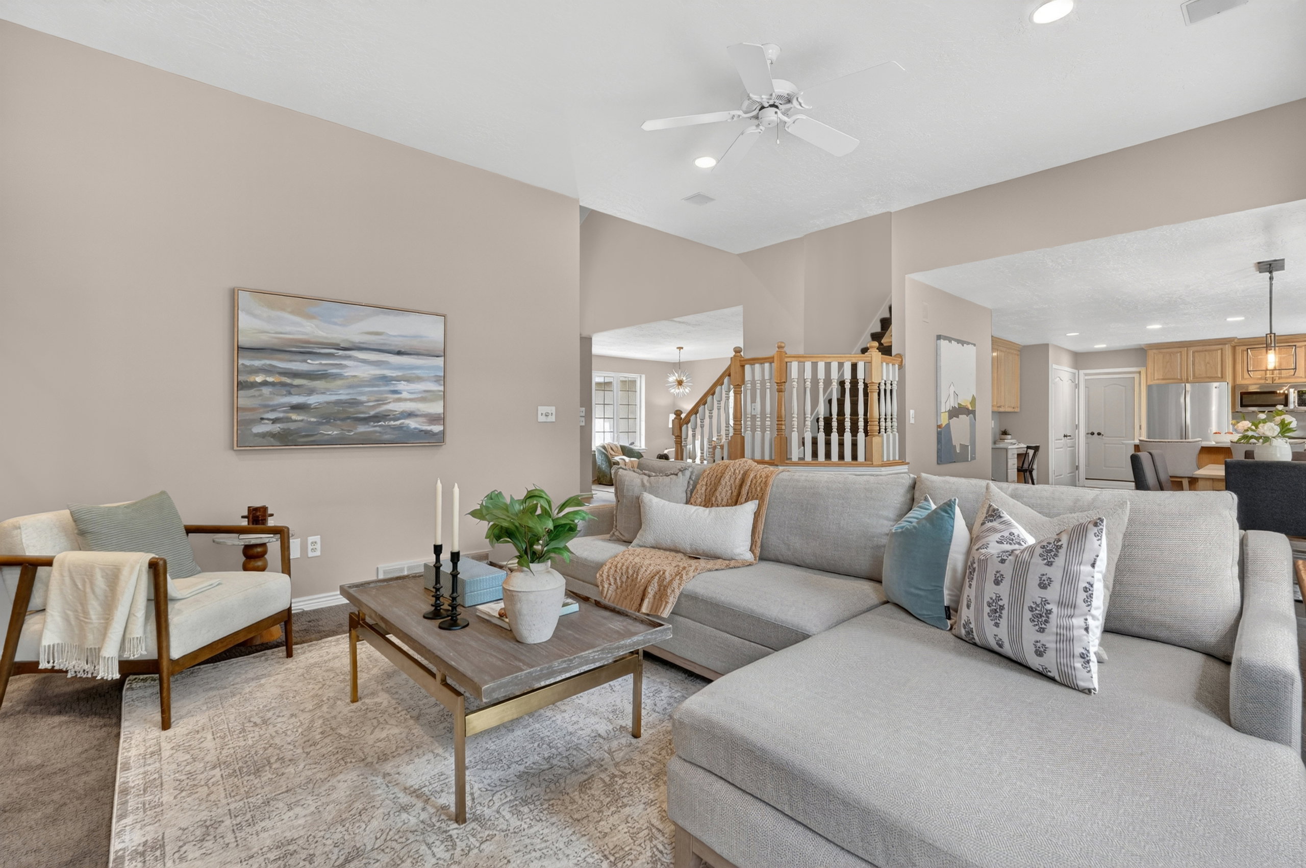 Spacious living area featuring a vaulted ceiling with a ceiling fan, recessed lighting, and a neutral color palette